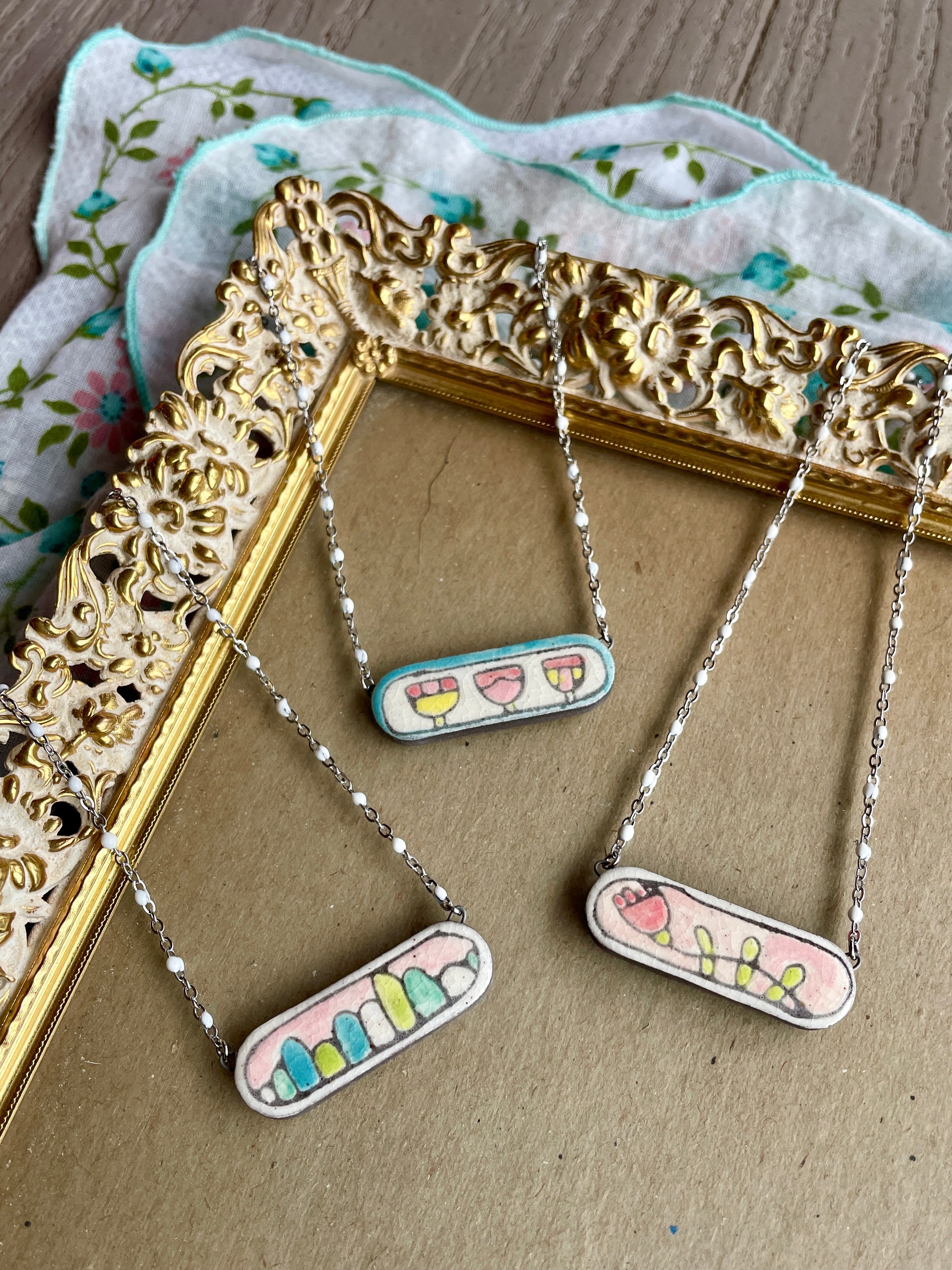 Unique ceramic necklaces that blend art and jewelry. Each piece is handcrafted and hand painted.