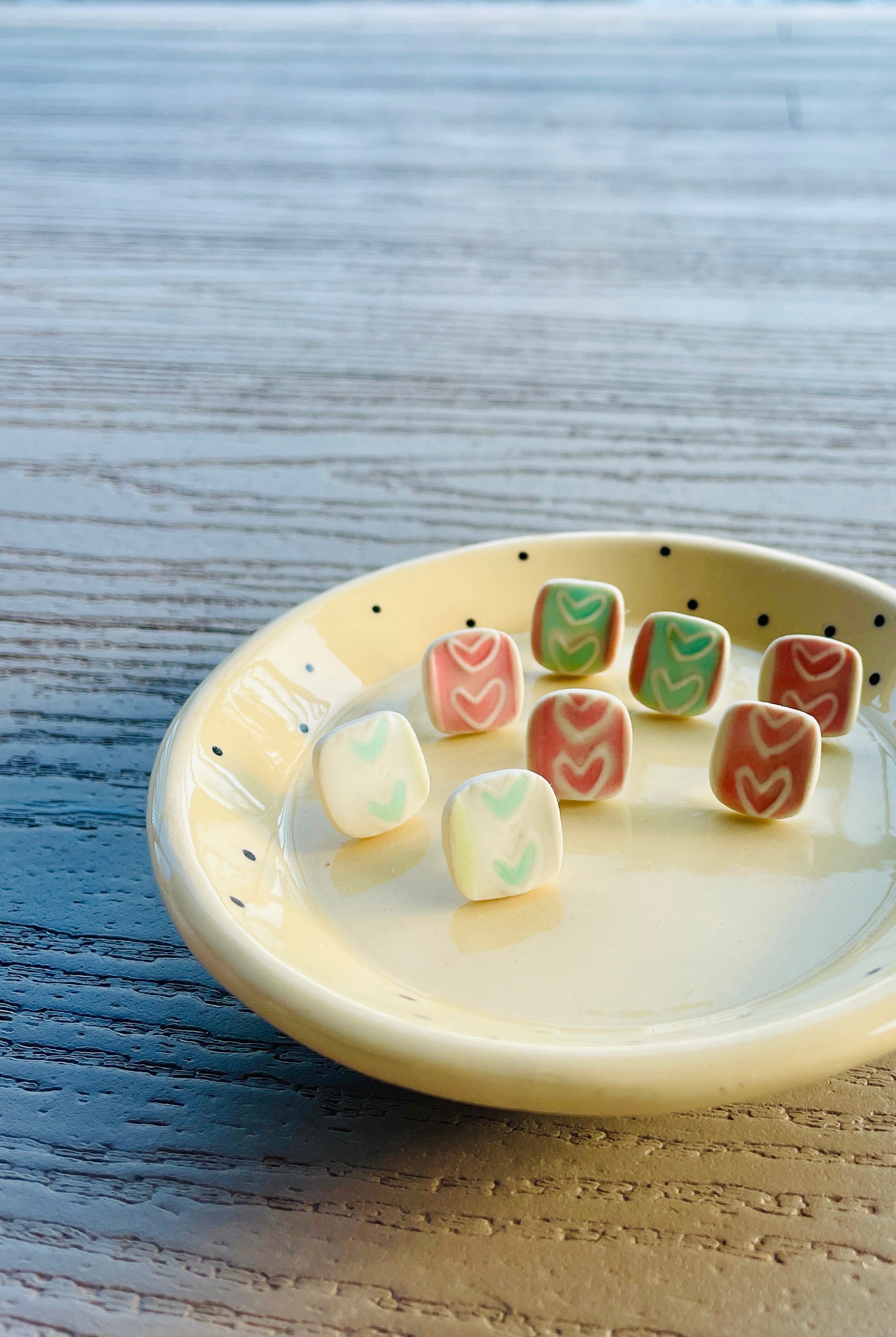 Handcrafted ceramic stud earrings with colorful hand-painted designs.